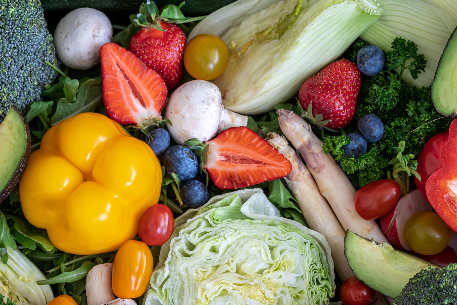 a woman standing in front of a display of fruits and vegetables
